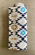 Load image into Gallery viewer, Organic Cotton Muslin Swaddle cloth with geometric Aztec print design in blue/black/gold. Cloth is rolled neatly.
