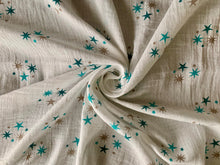 Load image into Gallery viewer, Organic Cotton Muslin Cloth with blue and gold stars in varying shades on white. Cloth is twisted decoratively to show design.
