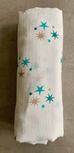 Load image into Gallery viewer, Organic Cotton Muslin Cloth with blue and gold stars varying shades on white. Cloth is rolled neatly on table.
