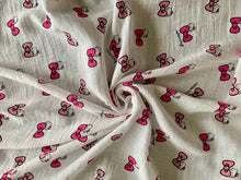 Load image into Gallery viewer, Organic Cotton Muslin Baby Swaddle Cloth with Pink Hello kitty and bows pattern on white. presented in a swirl pattern
