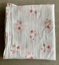 Load image into Gallery viewer, Organic Cotton Muslin Baby Swaddle Cloth with pink and gold star pattern on white.
