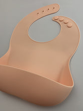 Load image into Gallery viewer, Silicone Bib BPA Free in light peach/butternut squash colour and 4 buttons with large crumb catcher scoop.
