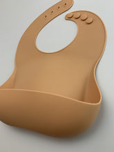 Load image into Gallery viewer, Silicone Bib BPA Free in light brown/camel colour and 4 buttons with large crumb catcher scoop.
