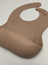 Load image into Gallery viewer, Silicone Bib BPA Free in a light brown/nude colour and 4 buttons with large crumb catcher scoop.
