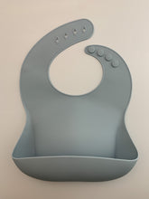 Load image into Gallery viewer, Silicone Bib BPA Free in a light blue/grey colour and 4 buttons with large crumb catcher scoop.
