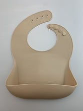 Load image into Gallery viewer, Silicone Bib BPA Free in a light brown/nude colour and 4 buttons with large crumb catcher scoop.
